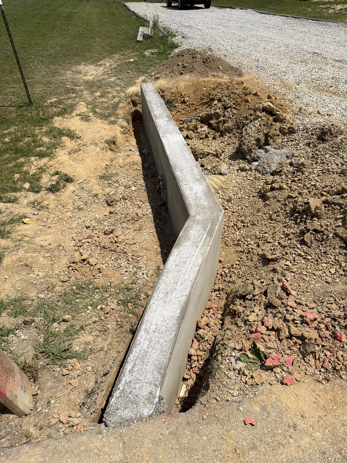 Concrete project by E & J General Contracting — Concrete Curb Pour in Louisville, KY (June 2026). Continuous concrete curb pour along the property edge — formed straight, poured in one run, and stripped clean to hold back the raised grade.