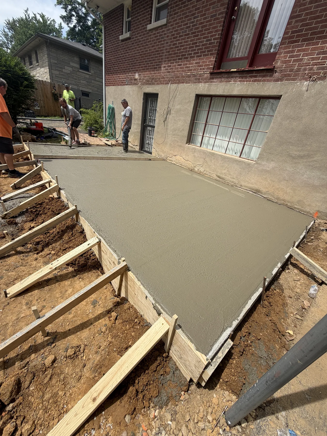 Concrete project by E & J General Contracting — Residential Concrete Patio in Louisville, KY (June 2026). New residential concrete patio from prep through finish. Formed, poured, and hand-finished with a clean broom texture and cut control joints for long-term crack control.